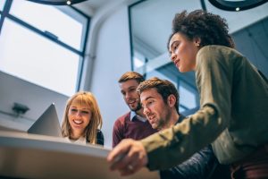 Low angle shot of coworkers looking at a laptop computer
